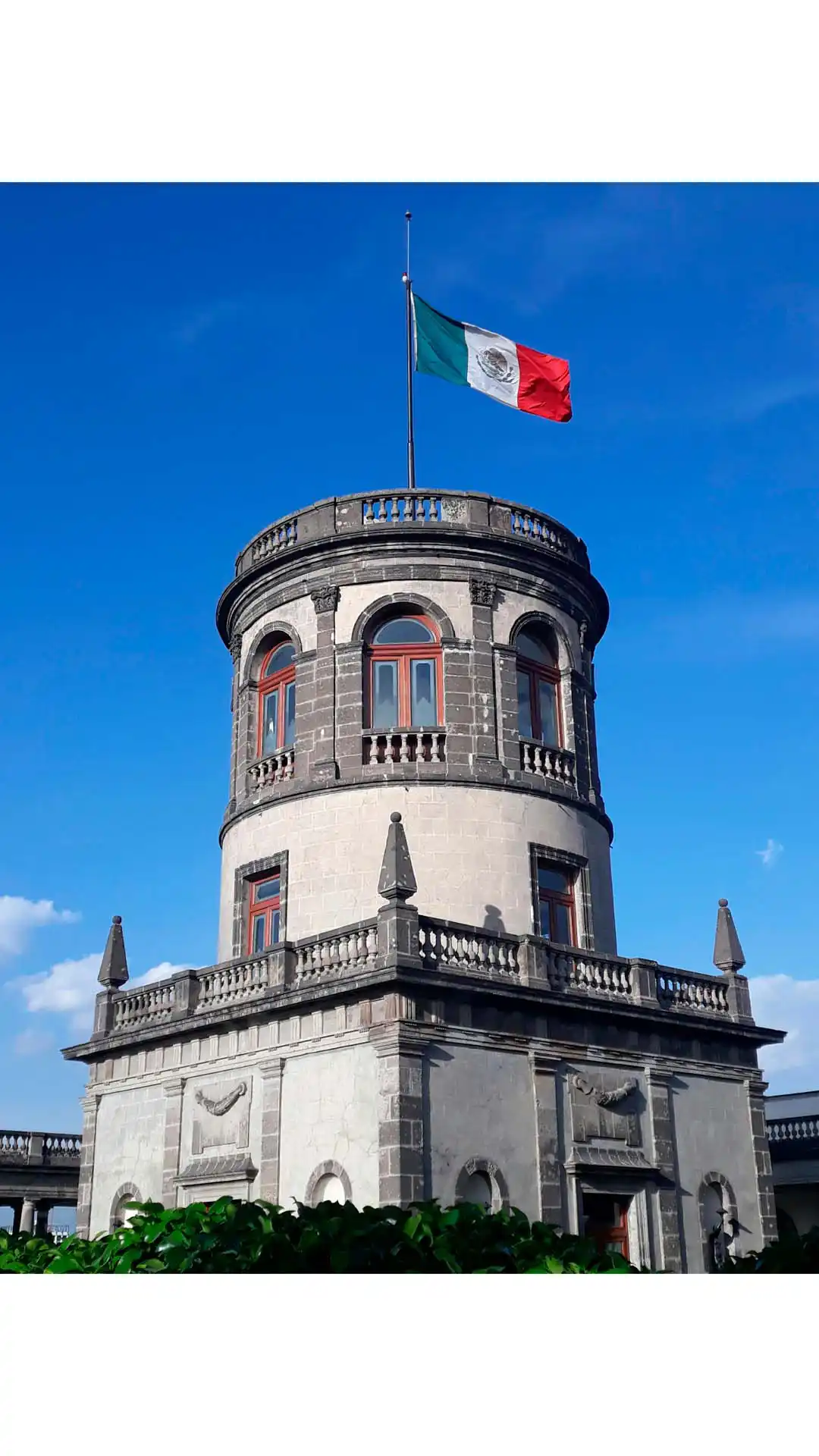 Castillo de Chapultepec con bandera de México ondeando bajo el cielo azul en Ciudad de México