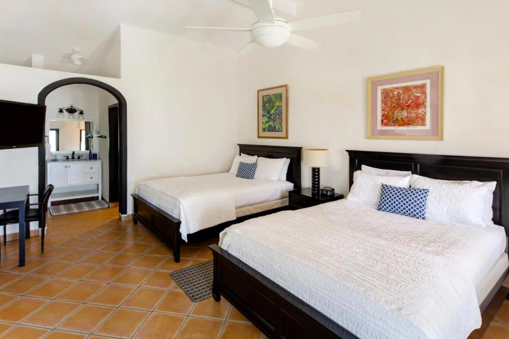 Habitación doble con camas matrimoniales, decoración mexicana y ambiente acogedor en hotel de Los Cabos, México.