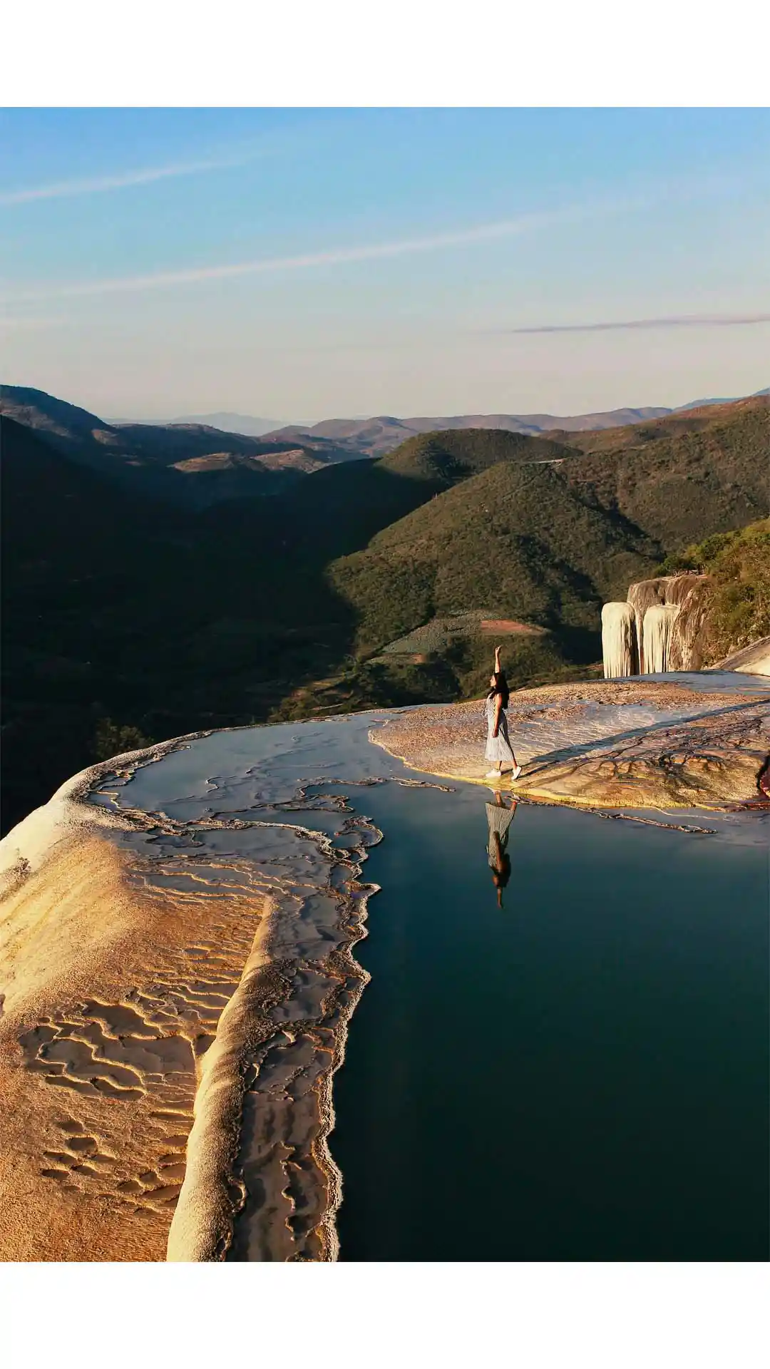 Turista disfrutando las formaciones naturales de Hierve el Agua en Oaxaca, rodeada de montañas y aguas minerales