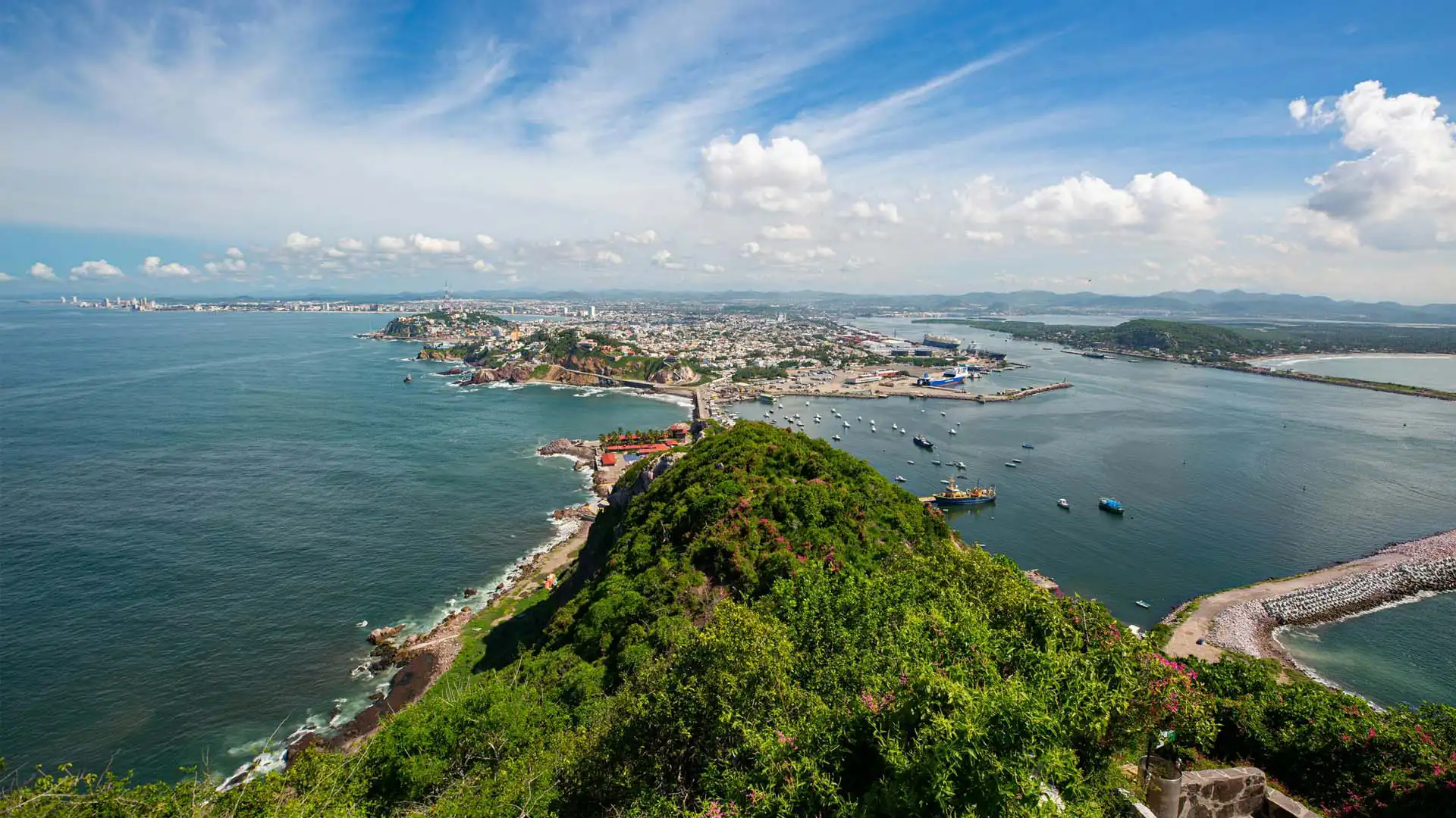Vista panorámica de Mazatlán con su costa, mar azul y puerto turístico desde un mirador
