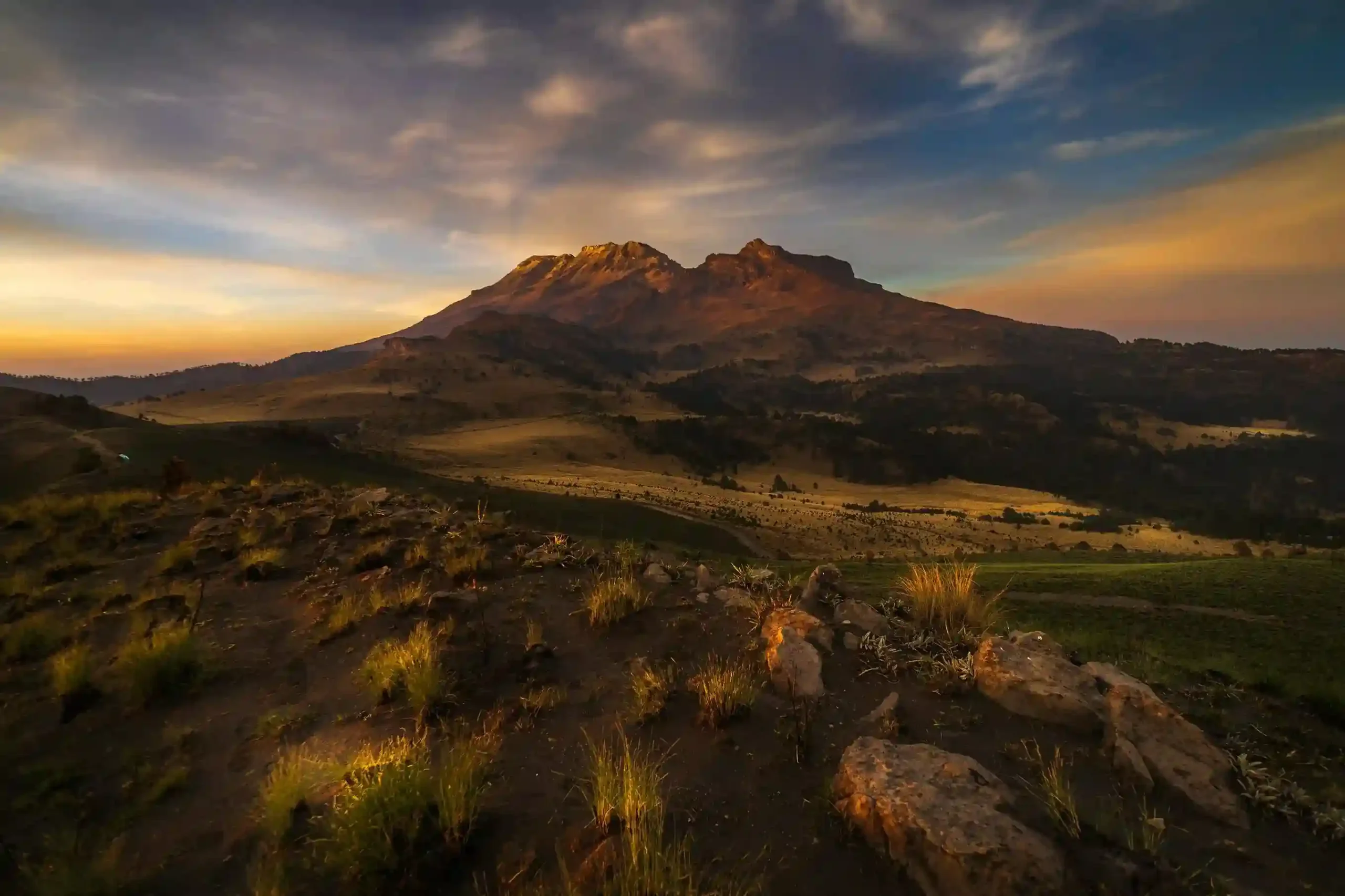 Paisaje del volcán Iztaccíhuatl al atardecer visto desde Puebla, rodeado de montañas y vegetación